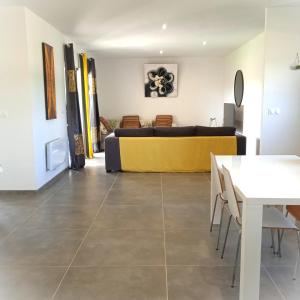 a living room with a couch and a table at La villa des Mûriers très spacieuse de 1 à 8 voyageurs avec lit bb dans un environnement calme dans les coteaux in Malause