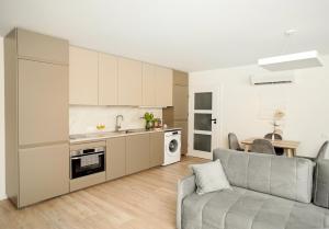 a living room with a couch and a kitchen at Apartamentai Saulėgrąža in Palanga
