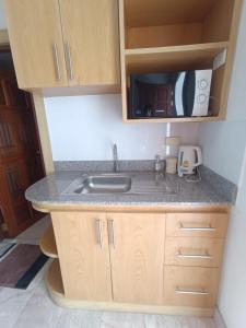 a kitchen with a sink and a microwave at Baan Klang condo in Hua Hin