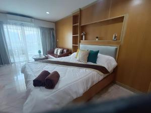 a bedroom with a large bed with towels on it at Baan Klang condo in Hua Hin