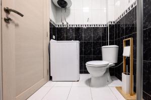 バールにあるApartmani Vukčevićの黒いタイル張りの壁、トイレ付きのバスルーム +44枚の写真