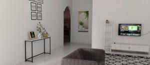 a living room with a couch and a tv at Tok Mek Homestay in Jertih