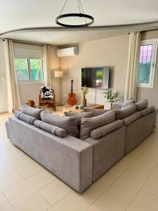 a large living room with a large couch at Nea Makri Holiday Villa - Garden Level in Nea Makri