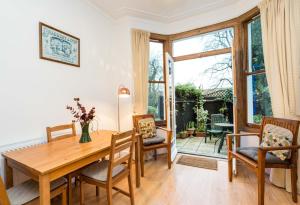 a dining room with a wooden table and chairs at NEW Stylish 1 Bedroom Flat with Garden | London in London