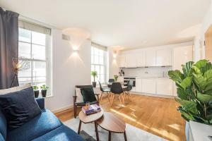 a living room with a blue couch and a table at Fantastic 1 Bedroom Flat Leicester Square West End in London