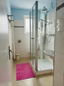 ein Bad mit einer Dusche und einem rosa Teppich in der Unterkunft Große Ferienwohnung mit Traumküche I 24 h Check in I Free Parking in Bielefeld