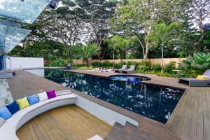a swimming pool in a backyard with a wooden deck at Canvas Boutique Hotel in Puerto Princesa City