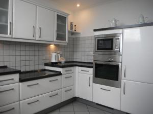 a kitchen with white appliances and white cabinets at Ferienwohnung Thoebarth in Wachtendonk