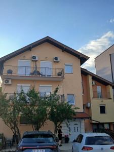 ein Gebäude mit zwei davor geparkten Autos in der Unterkunft N i N in Međugorje
