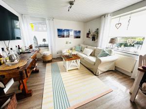 a living room with a couch and a table at Ferienhaus Norddeichkieker - Büsum in Norddeich