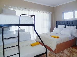 a bedroom with two bunk beds and a window at BKaap2 Queens and Kings Guest House in Cape Town