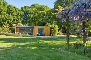 a house in a field with a tree at Independent rural detached annexe with free private Parking in Canterbury