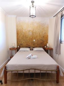 a bed in a room with a painting on the wall at Iliaxtida Apartment in Agia Paraskevi