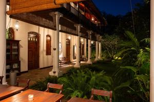 a restaurant with wooden tables and chairs in front of a building at Nyne Hotels Landesi - Galle Fort in Galle