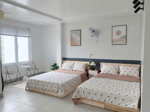 a bedroom with two beds and a table at Full House Cát Bà in Cat Ba