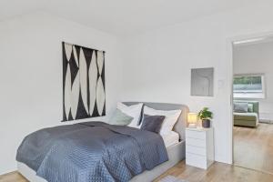 a white bedroom with a bed and a mirror at Dachgeschoss Traum Wohnung Ronsdorf 3 Zimmer in Wuppertal