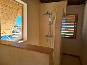 a shower in a bathroom with a window at Beheloka Lodge in Ambalaviro