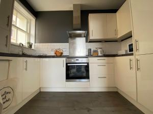 a kitchen with white cabinets and an oven at Spacious 2BD Flat with Stunning Views Folkestone in Folkestone