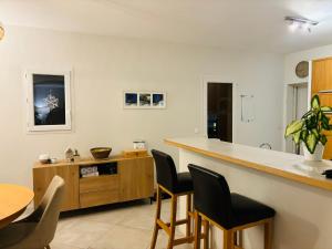a kitchen with a counter and a table and chairs at Villa Arles Trinquetaille in Arles