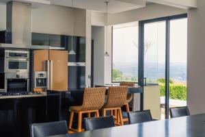 a kitchen with a counter with chairs and a table at La Montaña Mágica in Montenegro