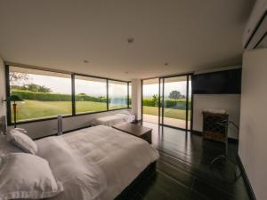 a bedroom with a large bed and a large window at La Montaña Mágica in Montenegro