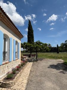 a building with a bench next to a tree at La Bastide des Launes près du Festival de Piano in La Roque-dʼAnthéron