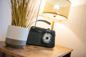 a black radio sitting on a table next to a lamp at Charming 2 Bedroom Flat in the Heart of Kirriemuir in Kirriemuir