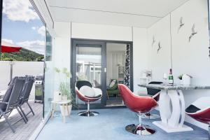 a living room with red chairs and a table at Ferienhaus Ufergeheimnis am Gülser Moselbogen I 2 SZ I 5 Gäste I Badebucht I Grill I Garten in Koblenz