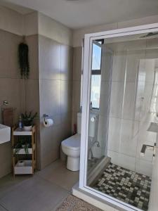 a bathroom with a toilet and a glass shower at 6 on Sunset Valley in Khomas Region +6 photos