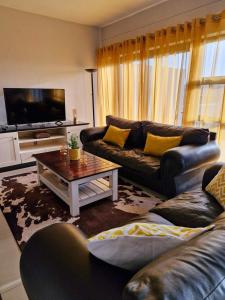 a living room with two couches and a tv at 6 on Sunset Valley in Khomas Region