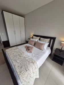 a large bed in a bedroom with a doll on it at 6 on Sunset Valley in Khomas Region