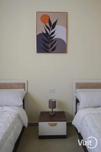 een kamer met twee bedden en een tafel ertussen bij VIZIT Hacienda Bay in El Alamein +88 foto's