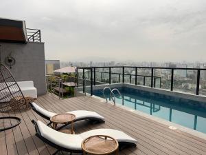 balkon z krzesłami i basen w budynku w obiekcie Departamento cálido y moderno w mieście Lima