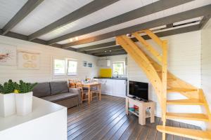 a living room and kitchen with a staircase in a tiny house at Hacienda-Dębina in Debina