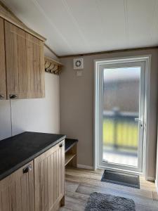 a kitchen with a large window and a counter at Sandy Lane 18 - Lodge with Hot Tub in Allerthorpe +2 photos