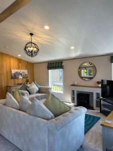 a living room with a large couch and a fireplace at Sandy Lane 18 - Lodge with Hot Tub in Allerthorpe