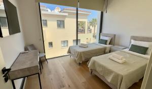 a room with two beds and a large window at Elysian Blue villa 4 in Paphos City +25 photos