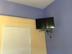 a television on the corner of a room with a door at House Souzanna in Toroni