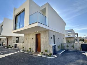 a large white house with a glass facade at Elysian Blue villa 4 in Paphos City