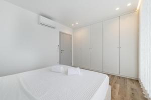 a white bedroom with a white bed and white cabinets at Casa do Horizonte in Vieira do Minho +11 photos