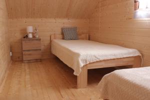a bedroom with two beds in a wooden cabin at Domki u Rybaka Wapnica in Wapnica
