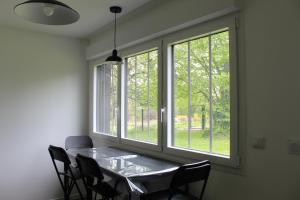 a dining room with a table and two windows at Les Coquelets in Hamars