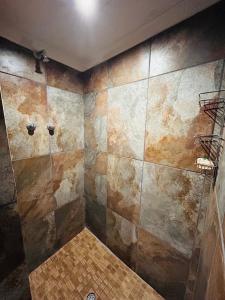 y baño con pared de azulejos y ducha. en Stonehouse, en Carolina