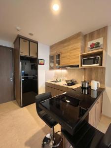 马卡萨Steph's APT 31 Sudirman Suites Makassar的房间里有黑色台面的厨房