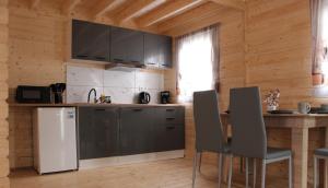 a kitchen with a refrigerator and a table with chairs at Domki u Rybaka Wapnica in Wapnica