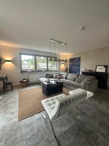 een woonkamer met een bank en een tafel bij Eifeeloft - Eifel erleben in Neroth +16 foto's