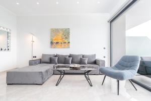 a living room with a couch and a table and chairs at Diamond Blue Villas Lefkada in Nydri