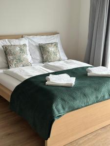 a bed with two towels on top of it at Sunny apartment BRNO in Královo Pole