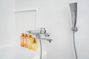 大阪市にあるSUIMEI Ebisuの黄色いオイルボトルが置かれたシャワー付きのバスルーム