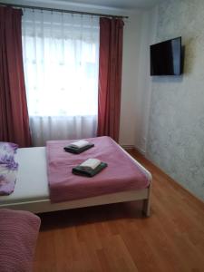 a bedroom with a bed with pink sheets and a window at Pokoje u Bożeny in Karwia